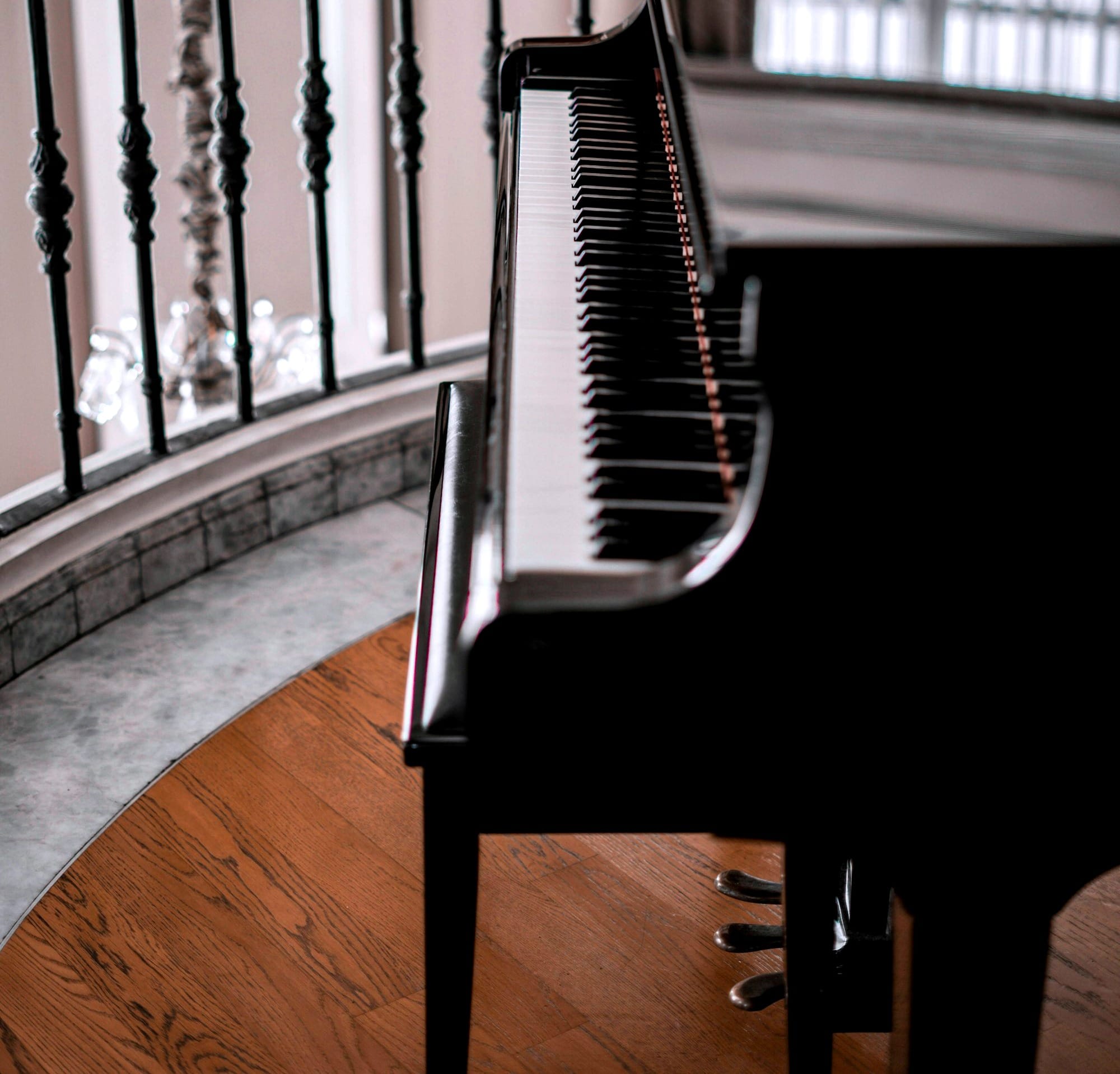 black upright piano on brown wooden floor